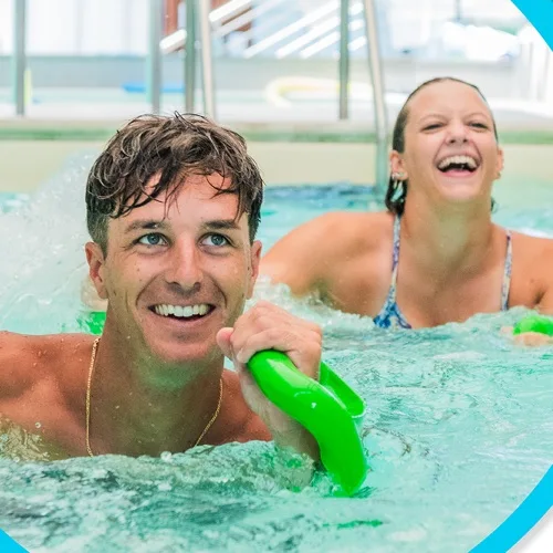 Due partecipanti sorridenti durante il fitness in acqua